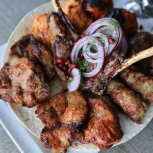 A mouthwatering assortment of grilled meats, served with onions and sauces. Perfect for dinner.